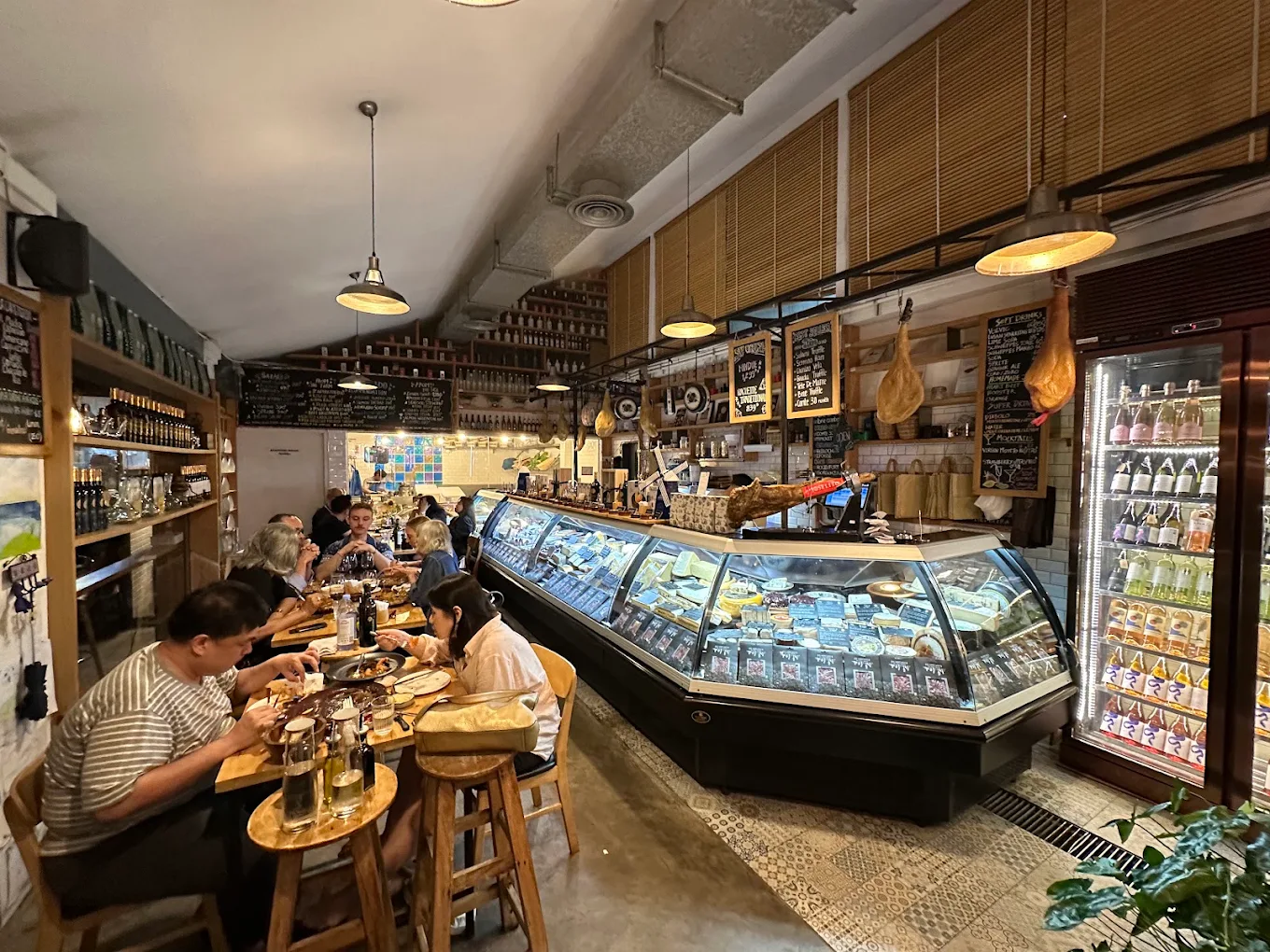 The long gastronomia room, its counter and hanging jamón