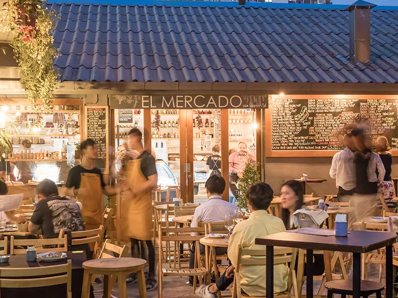 El Mercado's front at dusk, tables out under the tiled roof