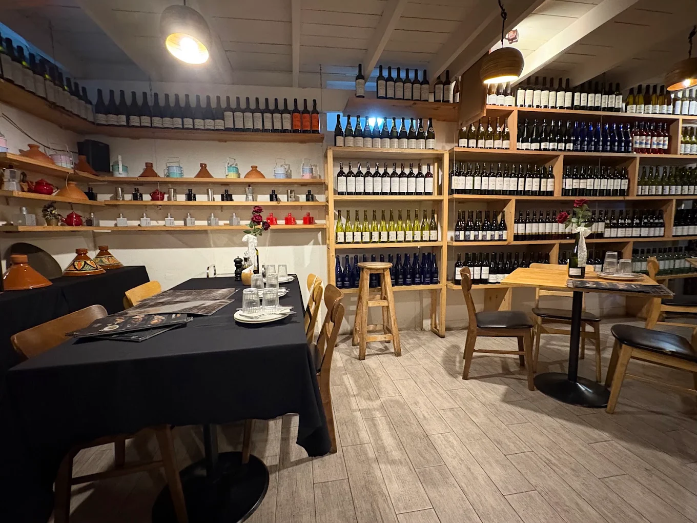 The wine room, walls of bottles and tables laid in black